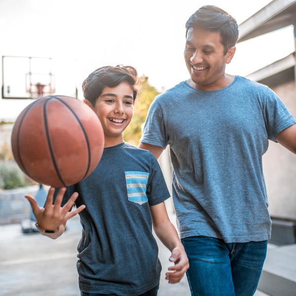 Father and son with basketball after son uses custom mouth guards in Pflugerville, TX.